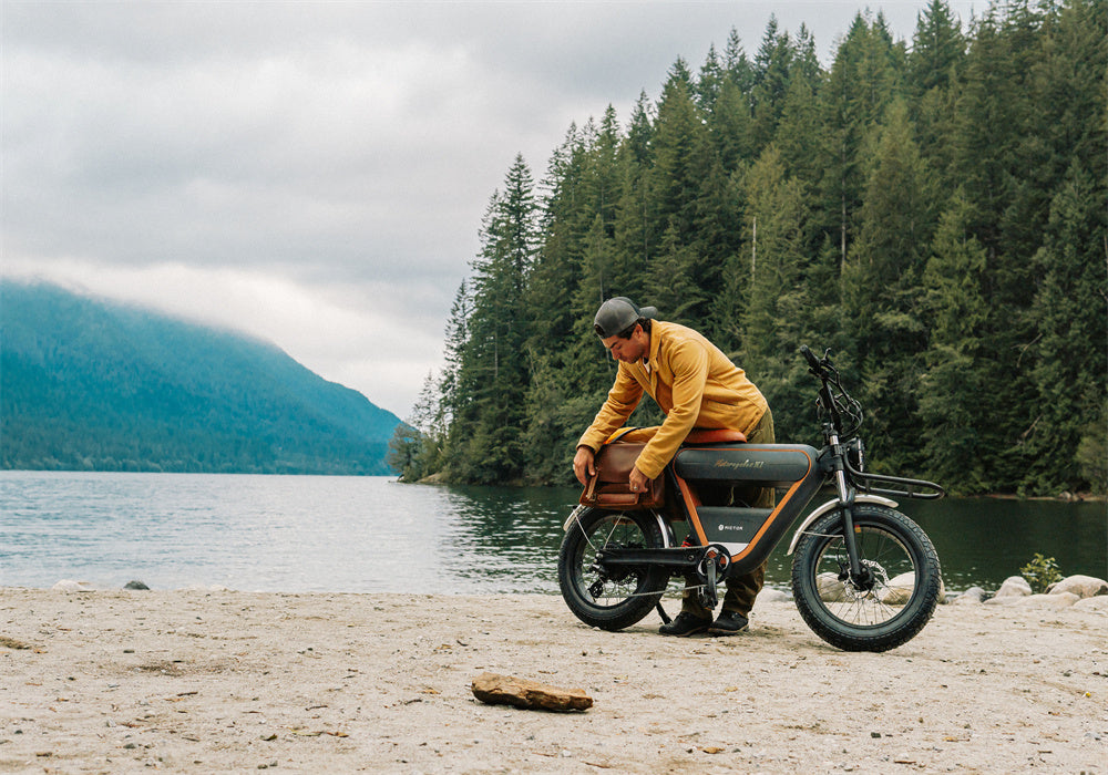 A man adjusts RICTOR K1 electric bike on a sandy beach